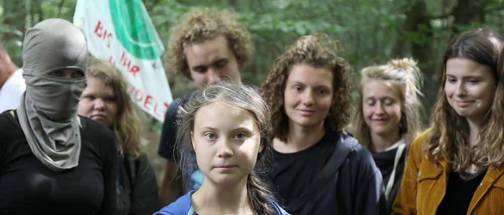 Greta Thunberg steht mit Aktivisten im Hambacher Forst, eine ist vermummt.