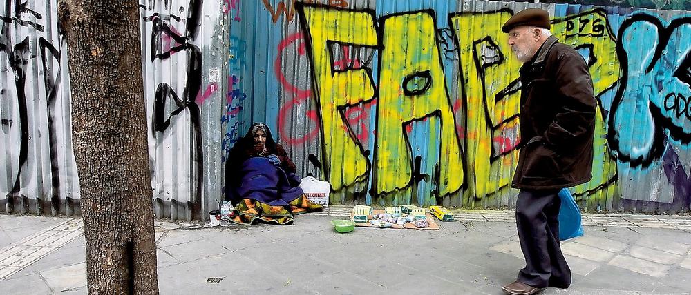 Ein obdachlose Frau bettelt in Athen um Geld. 
