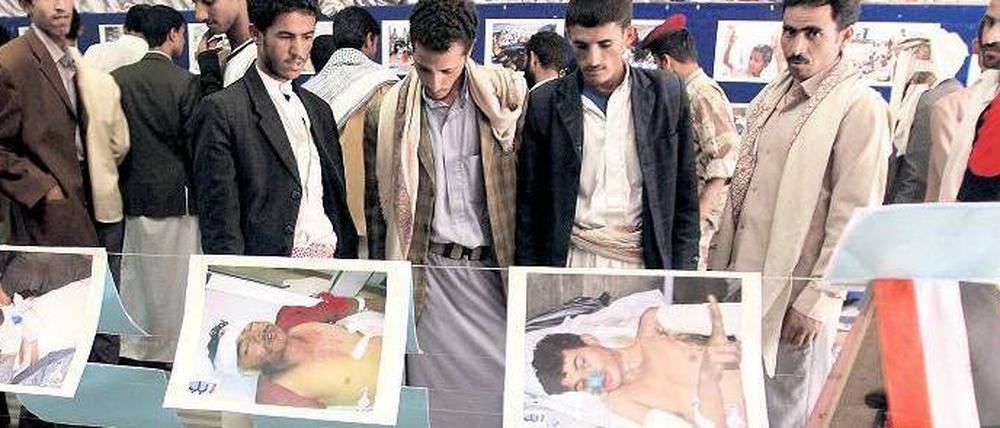 Schaurige Ausstellung. Besucher in der jemenitischen Hauptstadt Sanaa betrachten Fotos von Regierungsgegnern, die bei Demonstrationen und Kämpfen verletzt oder getötet wurden. 