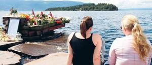 Utöya. Zwei Frauen sitzen beim temporären Mahnmal vis-a-vis der Insel nahe der norwegischen Hauptstadt Oslo, wo der Attentäter am vergangenen Freitag in einem Feriencamp unter zahlreichen Jugendlichen ein Massaker anrichtete. 
