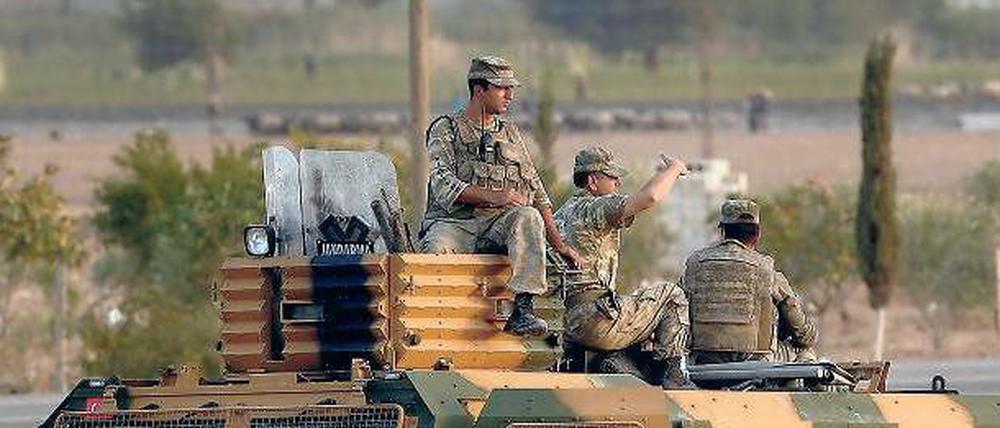 Militärbeobachter. Diese türkischen Soldaten betrachten dichte Rauchschwaden über Kobane, kurdische Verteidiger können momentan gegen den „Islamischen Staat“ bestehen. 