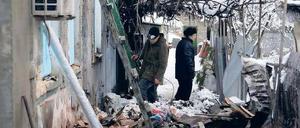 Einschläge. Bewohner eines bei Gefechten beschädigten Hauses in der ostukrainischen Stadt Donezk untersuchen die Auswirkungen der Angriffe. 