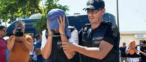 Ein türkischer Offizier, der nach Griechenland geflüchtet ist, wird von einem Polizisten zum Gericht geführt. 
