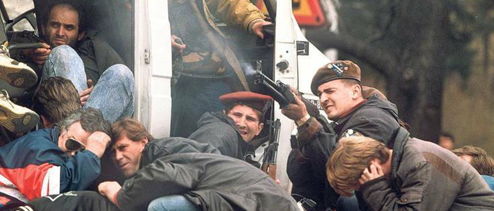 Umringt von schutzsuchenden Demonstranten erwidert ein bosnischer Soldat in Sarajewo am 6.April 1992 das Feuer eines serbischen Heckenschützen.
