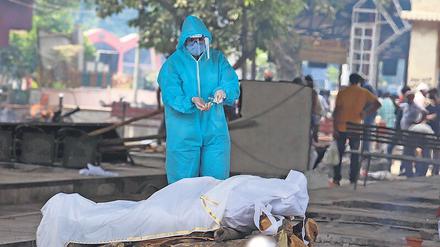 Im Ausnahmezustand. Ein Krematoriums-Angestellter in Neu-Delhi vollzieht die letzte Ölung bei einem Corona-Opfer. 