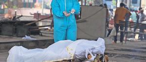 Im Ausnahmezustand. Ein Krematoriums-Angestellter in Neu-Delhi vollzieht die letzte Ölung bei einem Corona-Opfer. 