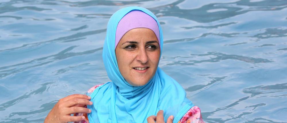 Eine Frau schwimmt im Burkini in einem Berliner Bad.