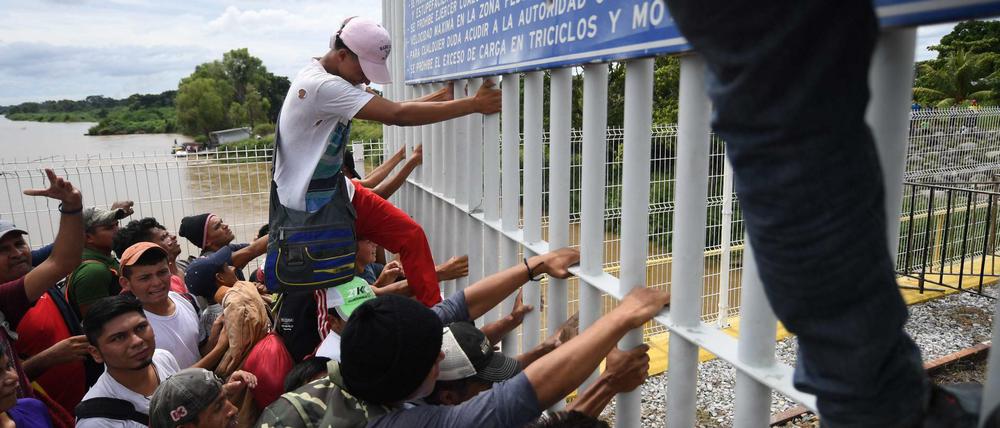 Migranten aus Honduras überwinden den Grenzzaun zwischen Guatemala und Mexiko.