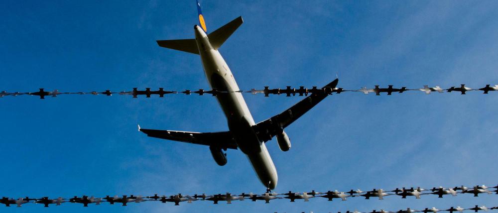 Ein Flugzeug fliegt am Flughafen in Hannover hinter Stacheldraht. 
