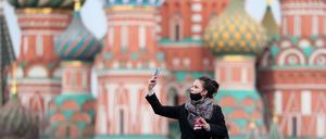 Eine junge Frau vor der Basilius-Kathedrale in Moskau. Russlands Hauptstadt ist schwer von der Corona-Pandemie betroffen.