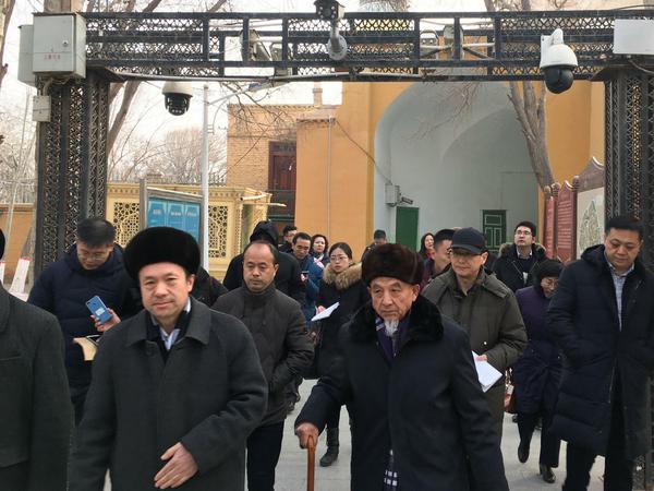 Imame und Regierungsbeamte vor Überwachungskameras bei einer Moschee in Kashgar, Xinjiang.