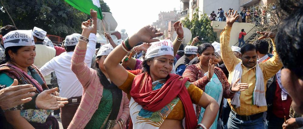 Anhänger der Antikorruptionspartei AAP feiern auf den Straßen Delhis.