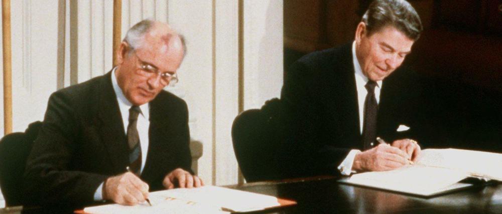 Der damalige sowjetische Parteichef Michail Gorbatschow (l) und der damalige US-Präsident Ronald Reagan unterzeichnen den INF-Vertrag zur Vernichtung der atomaren Mittelstreckenraketen.
