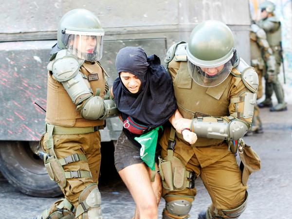 Die chilenische Polizei führt eine Demonstrantin ab.