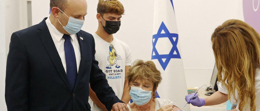 Israels Premier Naftali Bennett begleitet seine Mutter Myrna Bennett bei der Auffrischungsimpfung.
