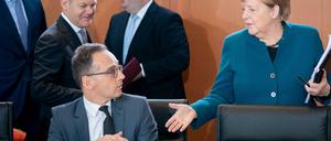 Heiko Maas (SPD), Außenminister, und Bundeskanzlerin Angela Merkel (CDU) begrüßen sich zu Beginn der Sitzung des Bundeskabinetts im Bundeskanzleramt.