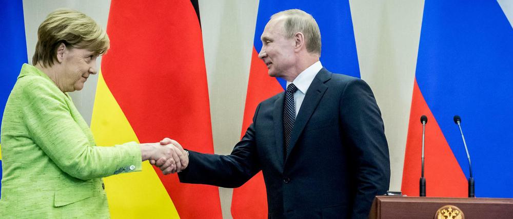 Bundeskanzlerin Angela Merkel und der russische Präsident Wladimir Putin reichen sich nach der Pressekonferenz am Dienstag in Sotschi die Hand. 