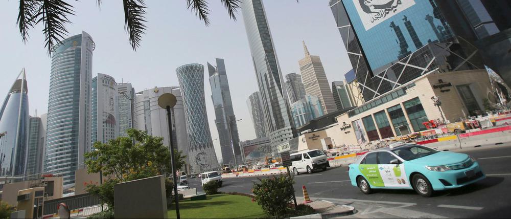 Ein Taxi fährt an einem Gebäude in der katarischen Hauptstadt Doha.