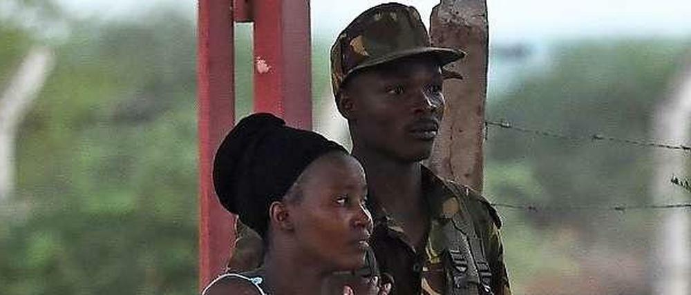 Ein Soldat begleitet eine Studentin, die seit dem Morgen in ihrem Wohnheim gefangen war, aus dem Campus. 500 Studenten konnten die Soldaten bei ihrer Erstürmung retten. Die Studenten waren im Schlaf von den Terroristen überrascht worden. 