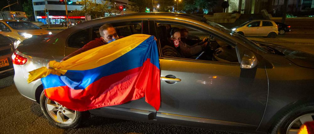 Anhänger des ehemaligen Präsidenten Uribe halten eine kolumbianische Flagge aus dem Auto und demonstrieren unter dem Motto «Wir unterstützen Uribe». Der Oberste Gerichtshof in Kolumbien hat den ehemaligen Präsidenten Uribe unter Hausarrest gestellt. 
