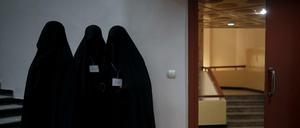 Drei in schwarze Burkas gehüllte Frauen vor einem Hörsaal der Universität in Kabul (Archivfoto).