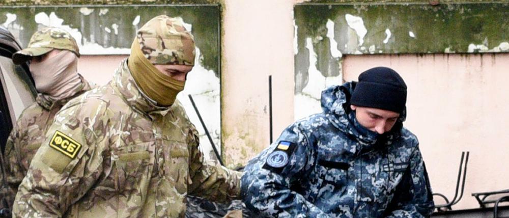 Ein gefangener ukrainischer Matrose wird abgeführt. 