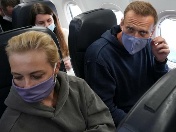 Der Kremlgegner Alexej Nawalny und seine Ehefrau Julia sitzen mit Mund-Nasen-Schutz im Flugzeug. 