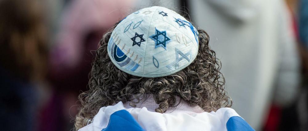 Eine Frau trägt auf einer Kundgebung eines Bündnisses gegen Antisemitismus eine Kippa.