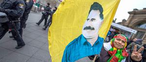 Eine Kurdin trägt in Frankfurt am Main eine Fahne mit dem Konterfei des PKK-Gründers Abdullah Öcalan.