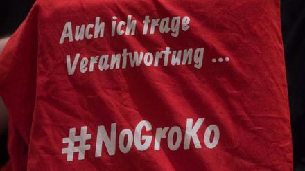 Ein Delegierter des SPD-Landesparteitages Sachsen-Anhalt zeigt einen Stoffbeutel mit der Aufschrift "#NoGroKo". 