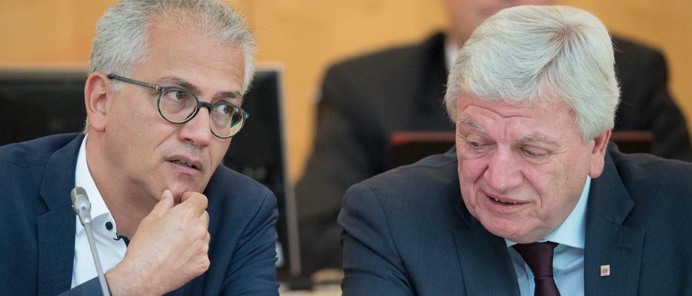 Wirtschaftsminister Tarek Al-Wazir (Grüne,l) und Hessens Ministerpräsident Volker Bouffier (CDU) unterhalten sich im Landtag.