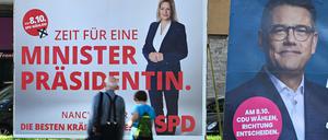 Wahlplakate der Spitzenkandidaten Boris Rhein (CDU, r), Ministerpräsident von Hessen, und Nancy Faeser (SPD), Bundesinnenministerin, stehen an einer Straße im Osten Frankfurts.