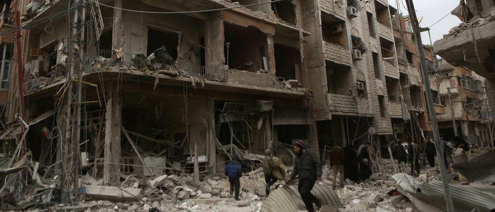 Syrer inspizieren Straßen und Gebäude, die durch Angriffe der syrischen Luftwaffe auf Ost-Ghouta zerstört wurden.