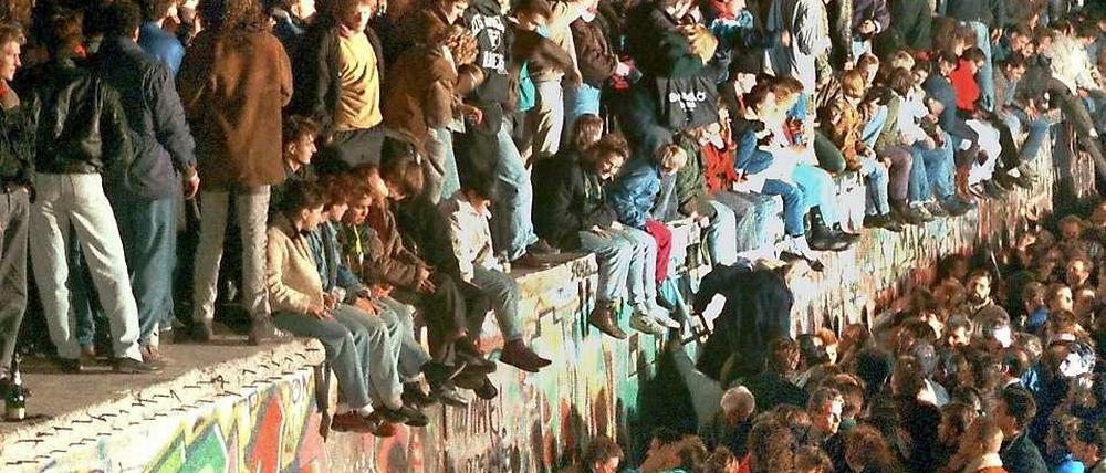 Stunde des Jubels. Feiernde Menschen auf der Berliner Mauer am 11. 11. 1989.