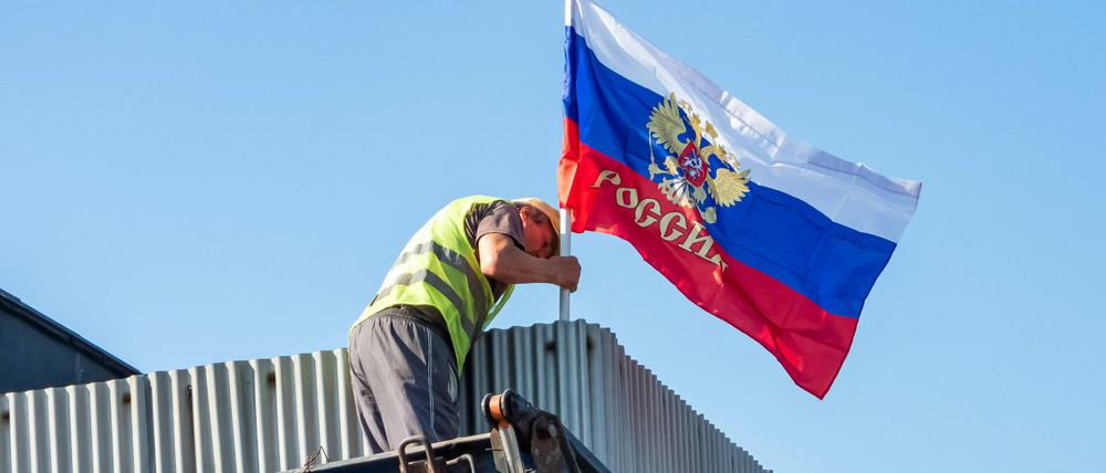 En Bauarbeiter hisst in der Region Saporischschja die russische Fahne (Archiv).