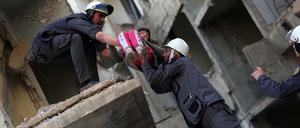 Nach einem Luftangriff: Mitglieder der syrischen Weißhelme bergen ein Mädchen aus einem zerbombten Gebäude.