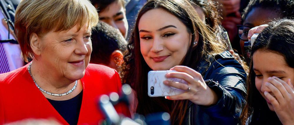 Auf gleicher Selfiehöhe: Was für die Kanzlerin - hier beim EU-Projekttag an einer Berliner Schule am Dienstag - selbstverständlich ist, sieht am Arbeitsplatz für Menschen mit Migrationsgeschichte oft ganz anders aus. 