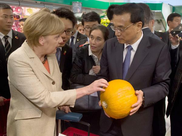 Fruchtbare Kooperation? Der Berliner Supermarktkürbis liegt in den Händen von Chinas Ministerpräsident Li Keqiang, der Ball zu einer neuen Chinapolitik allerdings bei Bundeskanzlerin Angela Merkel (Oktober 2014).