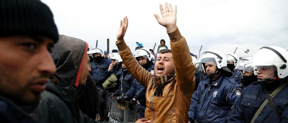 Konfrontation im Grenzgebiet: Ein Flüchtling zwischen anderen Flüchtlingen und griechischen Polizisten am Ostersonntag in Idomeni.