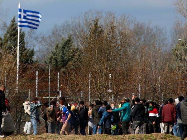 Migranten stehen auf türkischer Seite vor dem Grenzzaun zu Griechenland. 