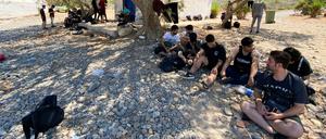 Gestrandet. Diese Flüchtlinge, die auf der griechischen Insel Kythira am Strand unter Bäumen sitzen, wollten gar nicht nach Griechenland, sondern von der Türkei nach Italien. Doch ihr Segelboot fuhr an der Küste der Insel auf Grund. 