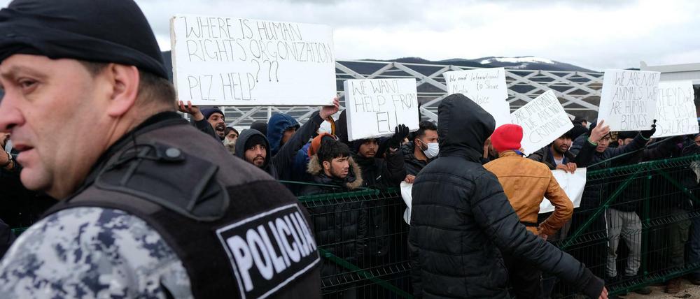 Migranten protestieren im Lager Lipa mit Plakaten gegen die schlechten Bedingungen. Nach der gescheiterten Verlegung von Hunderten Flüchtlingen in feste Unterkünfte im Landesinneren hat die bosnische Armee damit begonnen, in dem Elendslager im Nordwesten des Landes Zelte zu errichten. 
