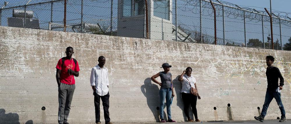 Eine Gruppe von Migranten an einer Mauer des Flüchtlingslagers Moria auf Lesbos. 