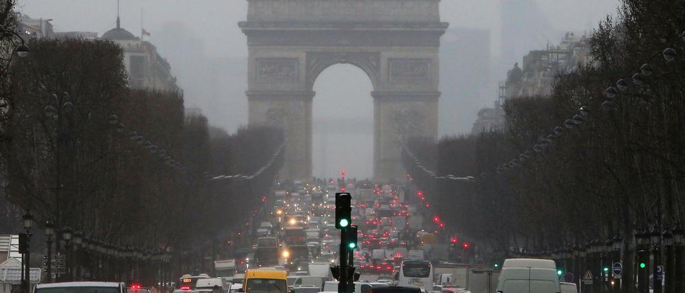 Autos fahren in Paris auf der Avenue des Champs-Élysées auf den Arc de Triomphe zu.