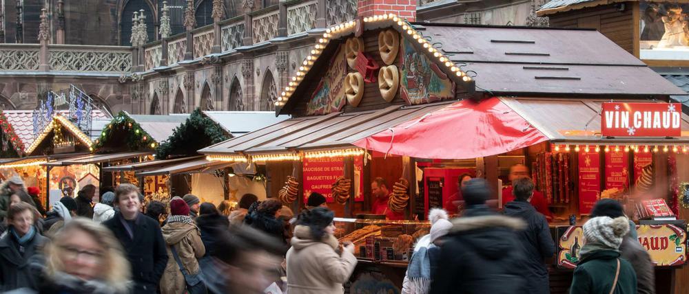 Menschen gehen einige Tage nach dem Attentat über den Weihnachtsmarkt in Straßburg.