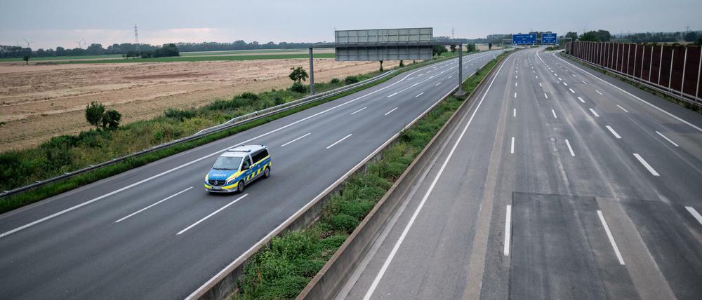 Ein Wagen der Polizei fährt über die gesperrte Autobahn A1 nahe Blessem in Erftstadt. 
