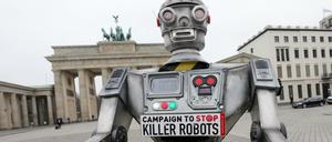 Eine Roboterfigur steht vor dem Brandenburger Tor. Der Nachbau ist Teil einer internationalen Kampagne der NGO "Facing Finance" zum Verbot von Killer-Robotern.