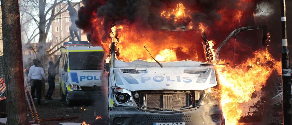 Polizeiautos brennen am Freitag am Rande einer rechtsextremen Kundgebung in Örebro.