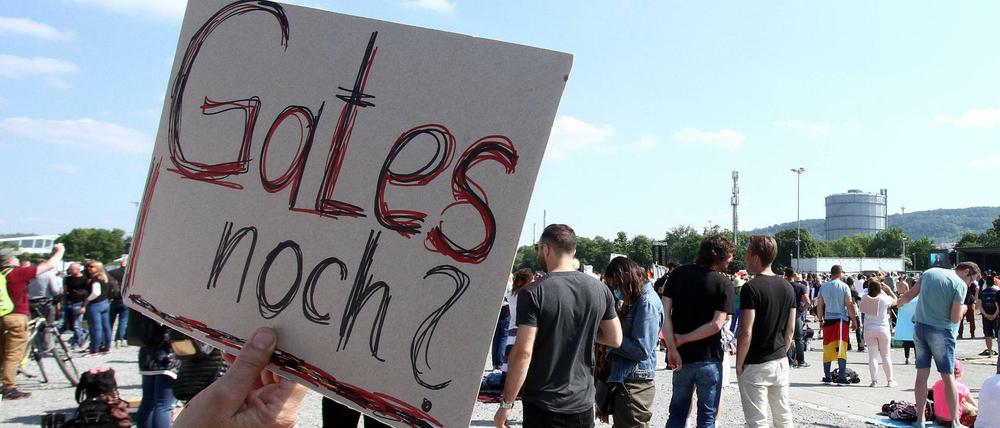 Auf einer Anti-Corona-Demo in Stuttgart hält eine Demonstrantin ein Plakat mit der Aufschrift "(Bill) Gates noch" hoch.