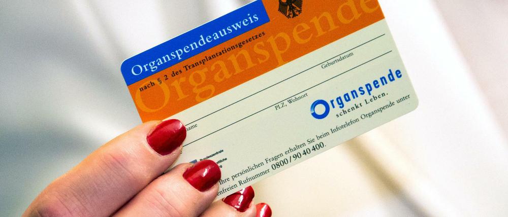 Eine Frau zeigt im Universitätsklinikum Schleswig-Holstein einen Organspendeausweis.